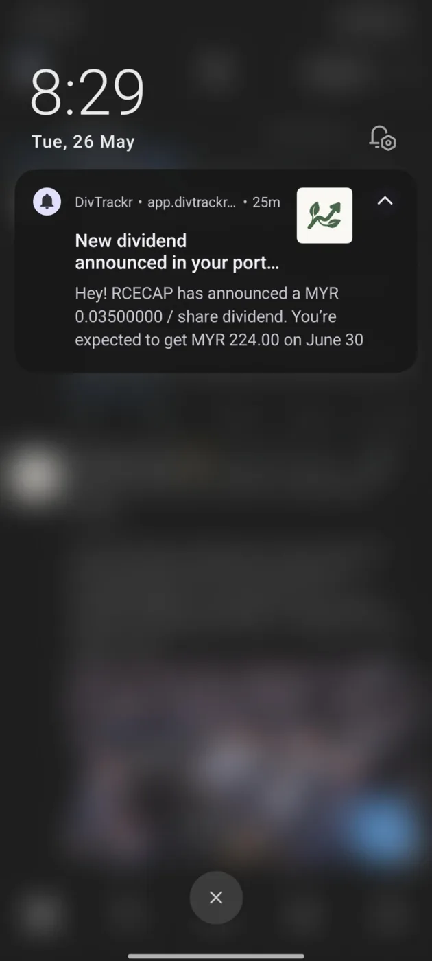 Phone lock screen showing a DivTrackr notification that RCECAP announced a dividend